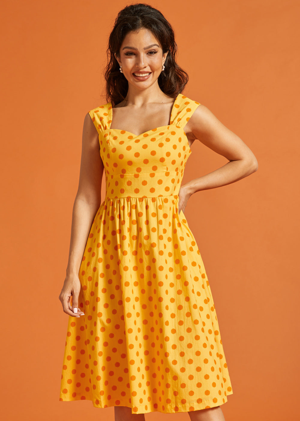 Woman wearing vintage-inspired yellow cotton midi dress with full skirt and side pockets.