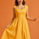 Front view of yellow cotton dress featuring a vintage-inspired silhouette and side pockets.