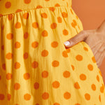 Detail of side pocket and painterly polka dot print on yellow cotton dress.