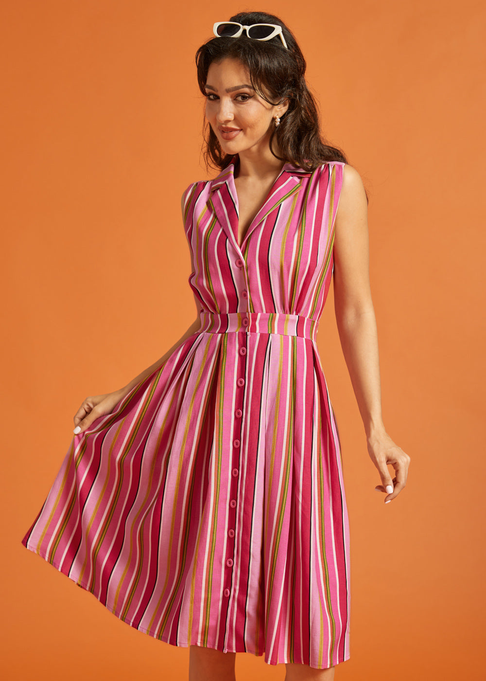 Woman modeling multicolored striped rayon blend midi dress with side pockets.