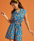 Woman wearing a retro-inspired viscose romper with roller skate print and side pockets.