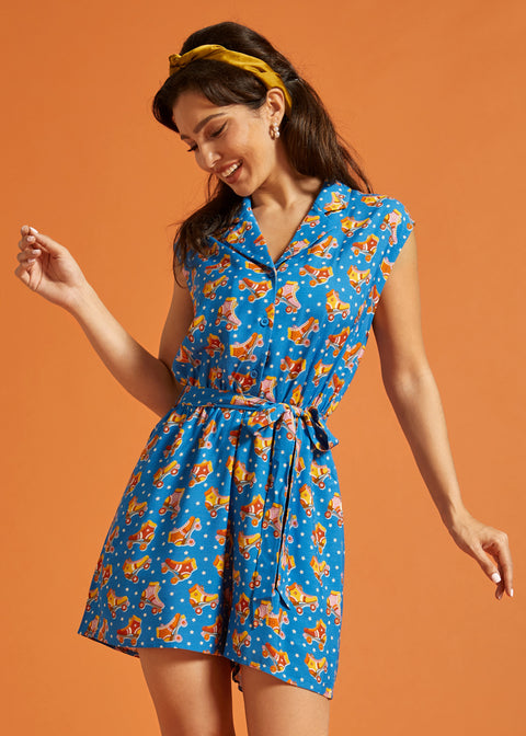 Woman wearing a retro-inspired viscose romper with roller skate print and side pockets.