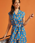 Front view of a blue novelty print romper with an adjustable tie belt.