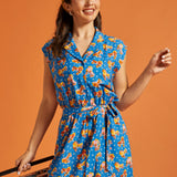 Front view of a blue novelty print romper with an adjustable tie belt.