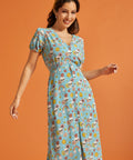 Woman wearing whimsical skull and floral print midi dress with tie waist.