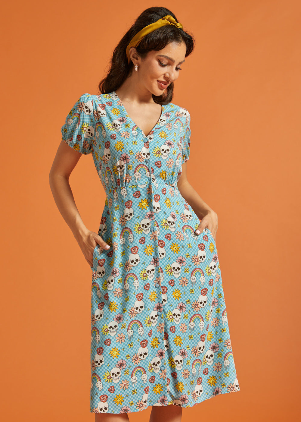 Woman modeling retro novelty print midi dress with functional front buttons and pockets.