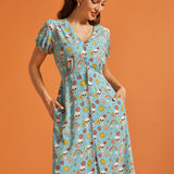 Woman modeling retro novelty print midi dress with functional front buttons and pockets.