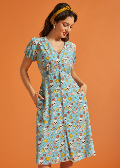 Woman modeling retro novelty print midi dress with functional front buttons and pockets.