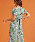 Back view of blue button-front midi dress with attached waist tie and puff sleeves.