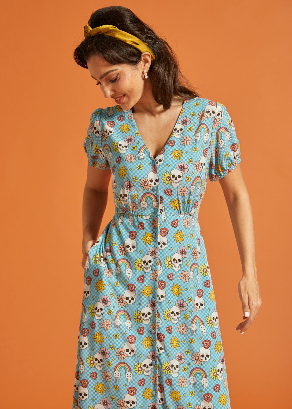 Woman wearing vintage-inspired viscose midi dress with V-neck and whimsical skull print.