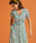 Woman wearing vintage-inspired viscose midi dress with V-neck and whimsical skull print.