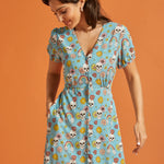 Woman wearing vintage-inspired viscose midi dress with V-neck and whimsical skull print.