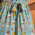 Close-up of attached self-tie waist on blue novelty skull and floral print dress.