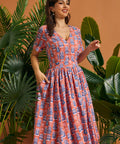 Woman modeling retro tropical novelty print midi dress with gathered skirt.