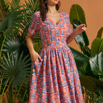 Woman modeling retro tropical novelty print midi dress with gathered skirt.