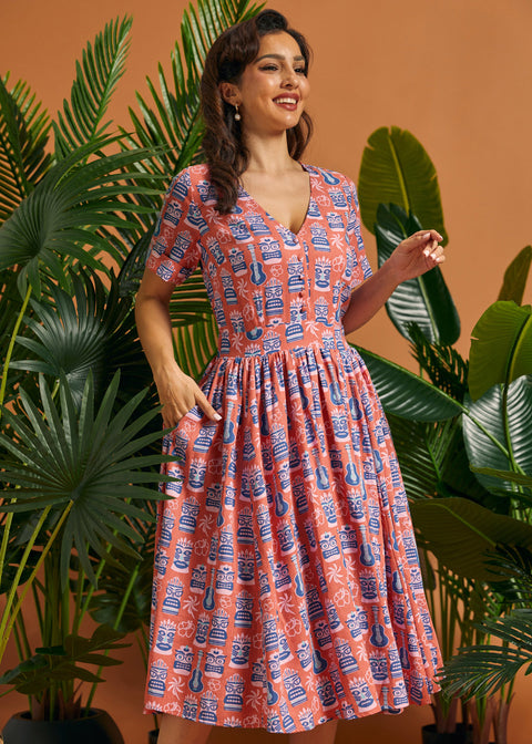 Woman modeling retro tropical novelty print midi dress with gathered skirt.