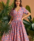 Woman wearing tropical novelty print midi dress with button-front bodice and full skirt.