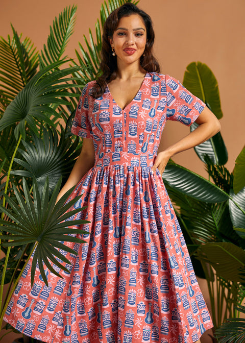 Woman wearing tropical novelty print midi dress with button-front bodice and full skirt.