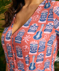 Close-up of V-neck button-front bodice featuring tiki mask and ukulele print.