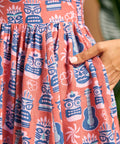 Close-up of side pocket and novelty tiki, ukulele and hibiscus print on linen blend dress.