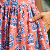 Close-up of side pocket and novelty tiki, ukulele and hibiscus print on linen blend dress.