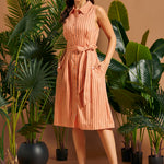Woman wearing a vintage-inspired button-front linen shirt dress with pockets.