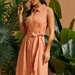 Woman wearing a peach pinstriped midi shirt dress with a waist tie.