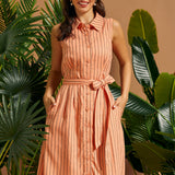 Woman wearing a peach striped sleeveless linen blend shirt dress with a self-tie waist.