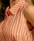 Close-up of the pointed collar and woven pinstripe fabric on a sleeveless shirt dress.