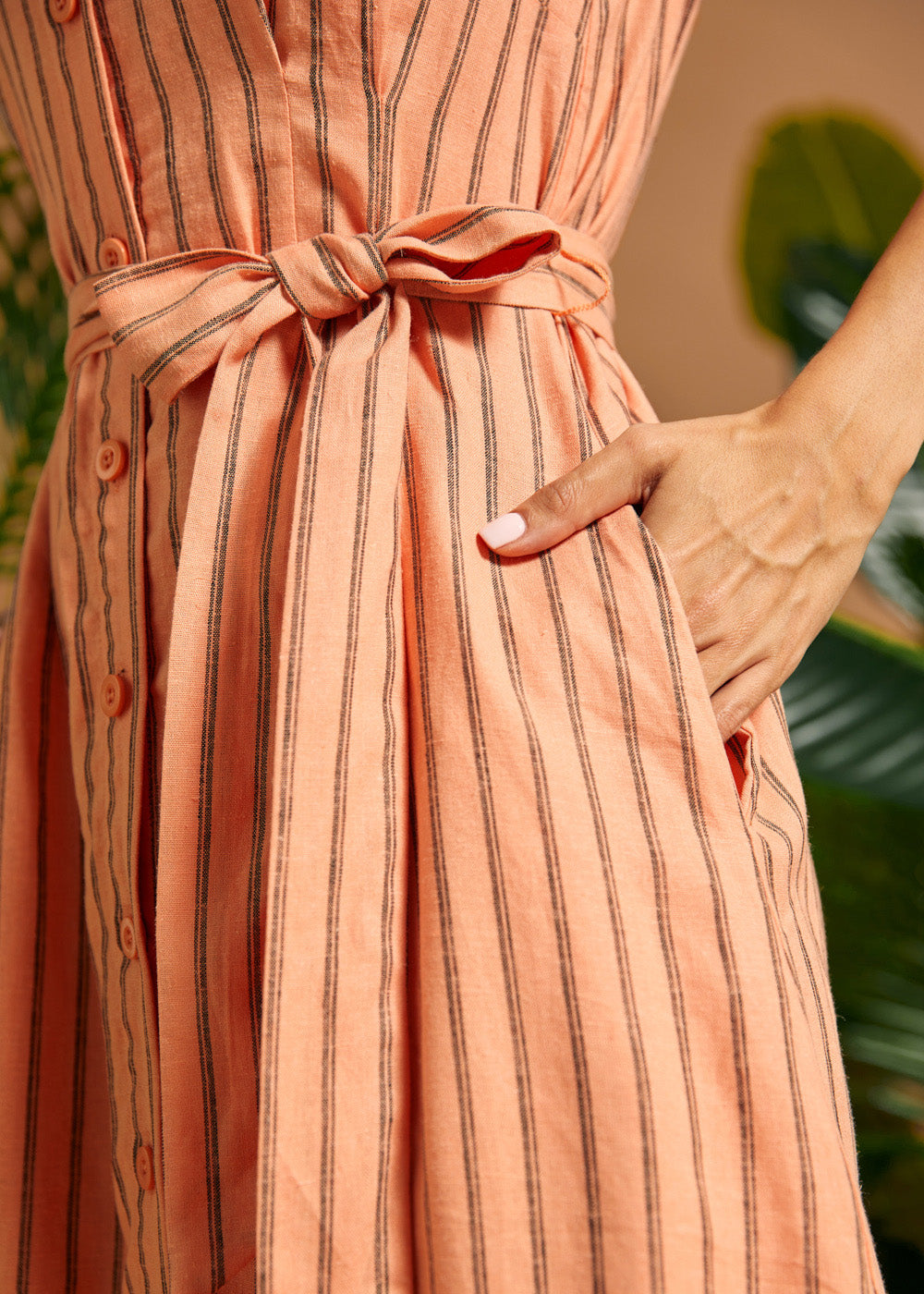 Close-up of the adjustable self-tie waist sash and side pocket.