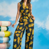 Woman wearing tropical leaf print tie-front shirt with matching wide-leg pants