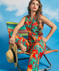 Woman lounging in tropical print retro resort outfit with tie-front top