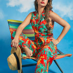 Woman lounging in tropical print retro resort outfit with tie-front top