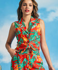 Woman wearing colorful tropical leaf print sleeveless blouse with front tie detail