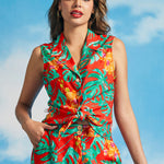 Woman wearing colorful tropical leaf print sleeveless blouse with front tie detail