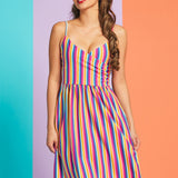 Woman wearing rainbow stripe sleeveless midi dress with surplice neckline and pockets
