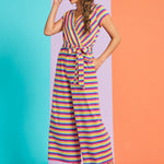 Woman wearing a colorful striped jumpsuit on a two-tone blue and orange background