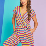 Model wearing rainbow stripe faux-wrap wide-leg jumpsuit with tie waist and pockets in Boardwalk Taffy