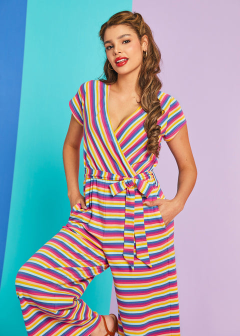 Model wearing rainbow stripe faux-wrap wide-leg jumpsuit with tie waist and pockets in Boardwalk Taffy