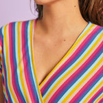 Close-up of faux-wrap neckline on rainbow stripe retro-inspired jumpsuit