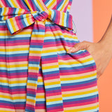 Close-up detail of tie waist and side pocket on colorful striped jumpsuit