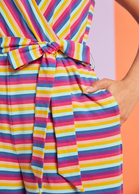 Close-up detail of tie waist and side pocket on colorful striped jumpsuit