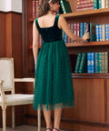 Back view of emerald green velvet tulle midi dress showing square back and zipper