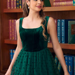 Close-up of woman wearing emerald green velvet dress with flocked polka dot tulle skirt