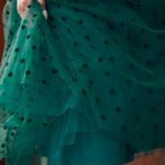 Close-up of layered emerald green flocked polka dot tulle skirt