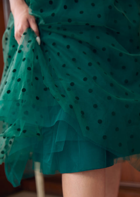 Close-up of layered emerald green flocked polka dot tulle skirt