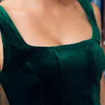 Close-up of emerald green velvet square neckline and princess seam bodice