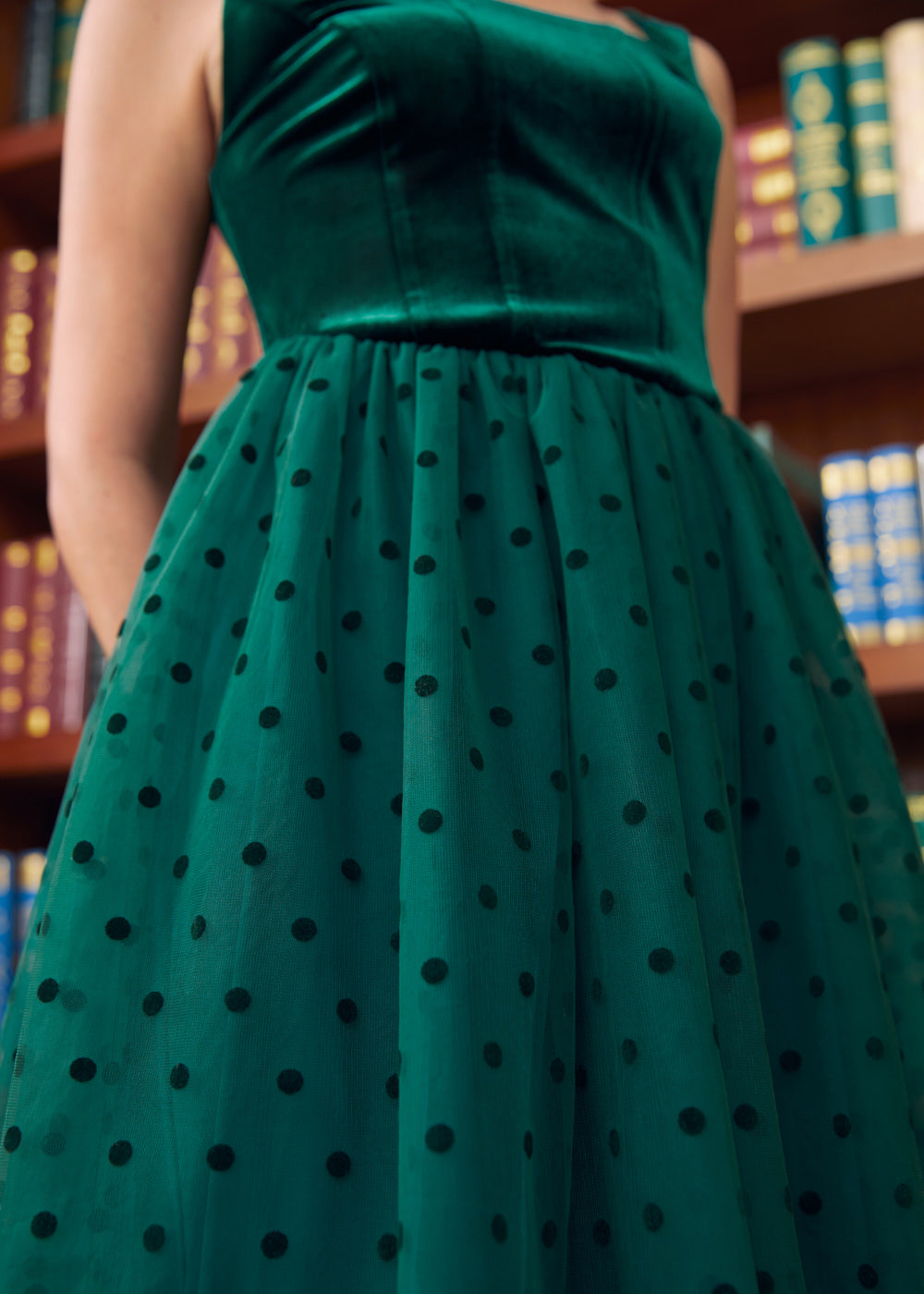 Close-up front view of emerald green velvet square neck bodice and polka dot tulle skirt