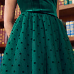 Close-up front view of emerald green velvet square neck bodice and polka dot tulle skirt