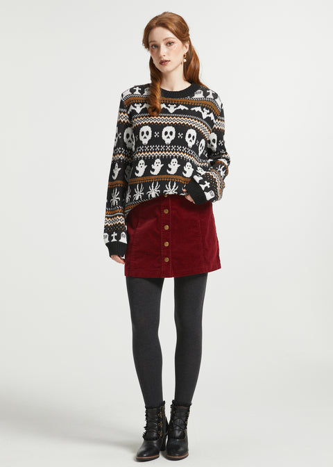 Full-length view of woman styling a spooky Fair Isle Halloween sweater with a burgundy corduroy mini skirt and lace-up boots for fall.
